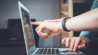 People pointing at laptop screen